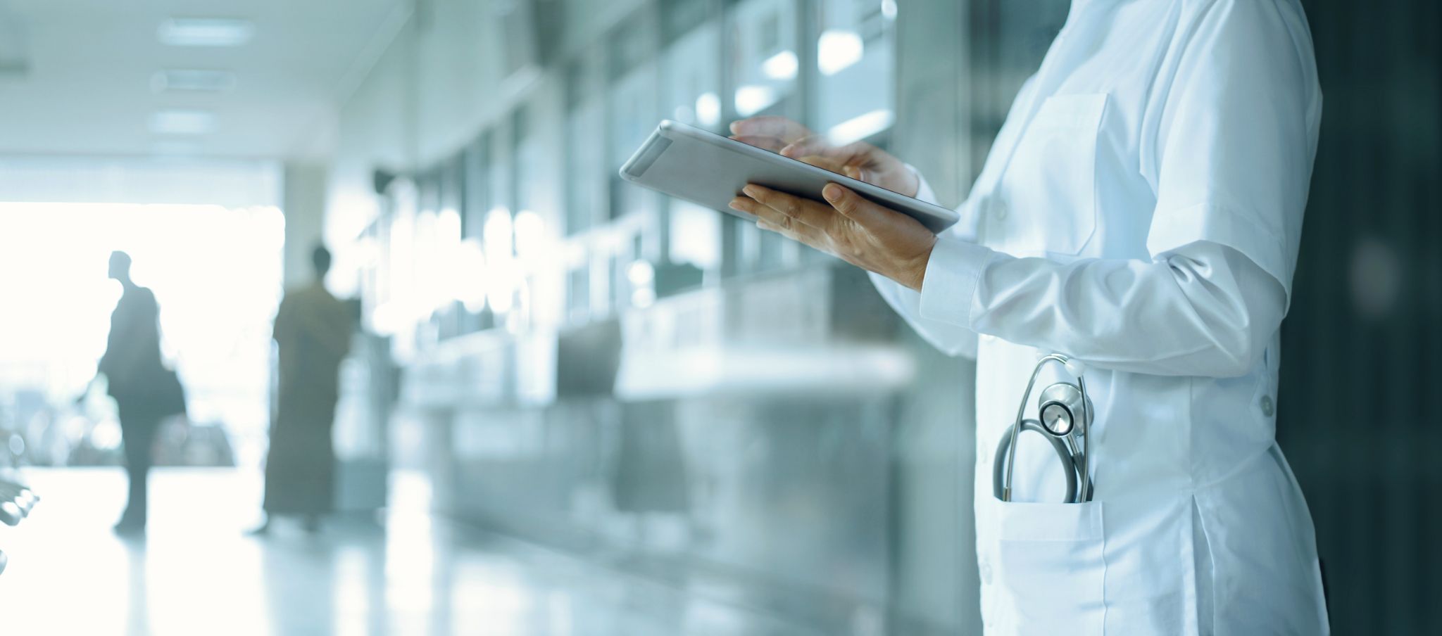 Doctor working on digital tablet on hospital background.