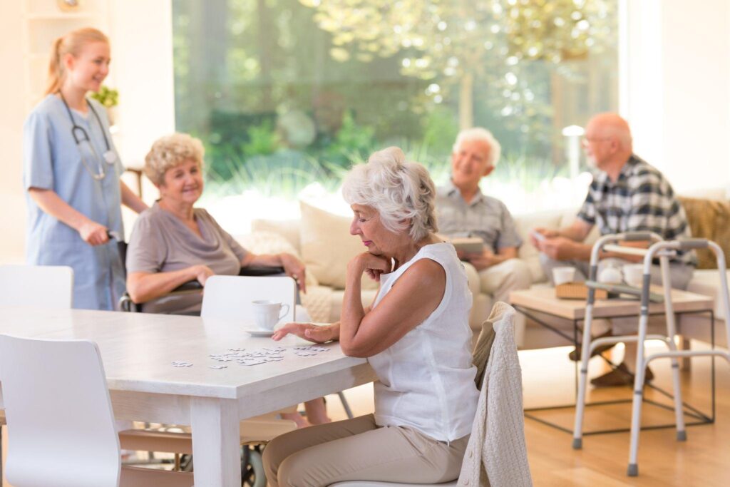 Senior woman doing puzzles at the table during her free time at the nursing house