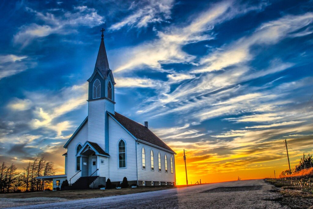 A lone wooden church at dusk with sunset clouds