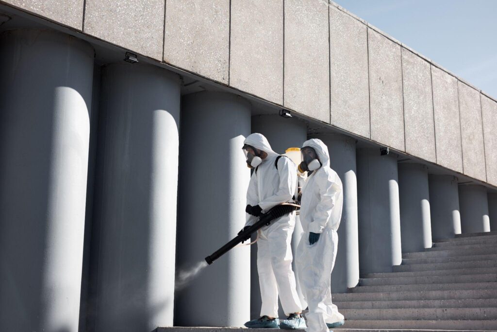 specialized friendly team in protective suits clean surface with equipment
